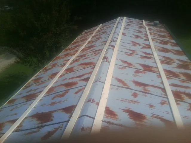 Rusted metal roof panels with new wood purlins before replacement — Storm Damage Roof Repair in Pomona Park by Roofing Brothers