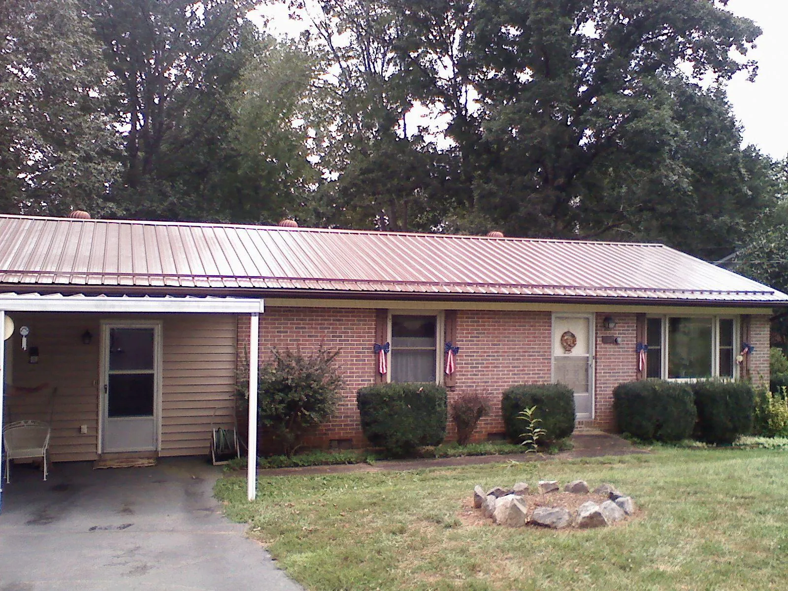 Bronze metal roof and carport on a brick ranch home — Roof Repair work by our crew in Pomona Park